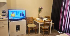 a small kitchen with a table with a tv on it at Sun Sea 2 in Shkorpilovtsi