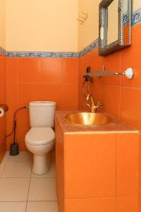 an orange bathroom with a sink and a toilet at Atlas Sud panorama in Imlil