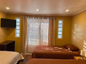 a bedroom with two beds and a window at NurHome in Mejillones