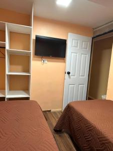 a room with a bed and a tv on a wall at NurHome in Mejillones