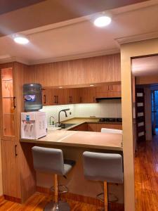a kitchen with wooden cabinets and a white microwave at NurHome in Mejillones
