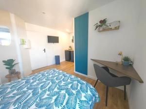a bedroom with a bed and a table and a chair at Azur, Cosy Blue studio, ultra centre de Desvres in Desvres