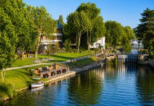 a river with tables and chairs next to a canal at Park View En-Suite in Egham