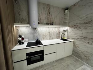 a kitchen with white cabinets and a sink at Bila Perlyna - Люкс, пляж, паркінг, укриття in Odesa +12 photos