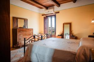 a bedroom with a bed and a dresser and a window at Tenuta la Selva Casa I Lavatoi in Casal Velino