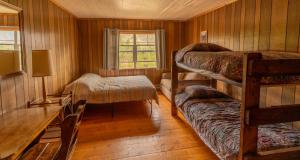 a room with bunk beds and a table and a desk at Shadowcliff Mountain Lodge & Retreat Center in Grand Lake