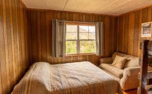 a bedroom with a bed and a window and a couch at Shadowcliff Mountain Lodge & Retreat Center in Grand Lake +6 photos