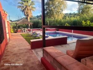 a swimming pool in a house with a patio at La Finca Roja una in Málaga