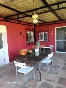 a table and chairs on a patio with a red wall at La Finca Roja una in Málaga