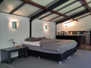 a bedroom with a large bed and a table at Hof van Vijfeijken in Boxtel