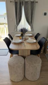 a wooden table with chairs and a dining room at Big Boss Caravan-Camber Sands,Sleep 8, Free Wi-Fi, Netflix, Parking in Camber