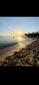 a sunset on a beach with a boat in the water at Casa Birmano in Taranto