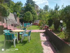 a patio with chairs and a table in the grass at BHURBAN view APARTMENTS in Murree