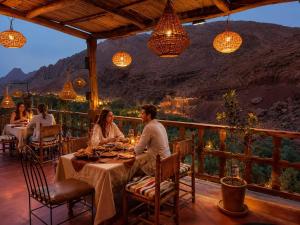 a group of people sitting at a table in a restaurant at Hotel Atlas Gorge Dades in Boumalne Dades