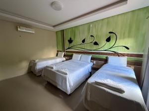 two beds in a room with a painting on the wall at Pousada Pedra Grande in Morros +57 photos