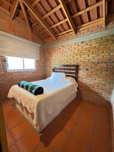 a bedroom with a bed in a brick wall at Cabañas Splash Valladolid in Jesús María