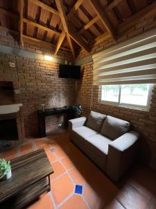 a living room with a couch and a fireplace at Cabañas Splash Valladolid in Jesús María