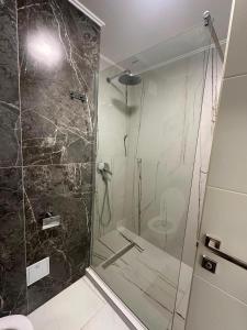 a shower with a glass door in a bathroom at Marevento Hotel in Costinesti