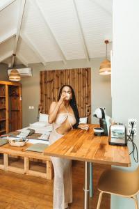 a woman sitting at a table in a room at EDEN FOREST VILLA in Pointe-Noire
