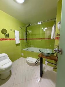 a bathroom with a toilet and a sink and a tub at Apartahotel Vincent Suites in Pasto +44 photos
