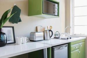 a kitchen with green cabinets and a white counter top at Stylish 1BR in Durban