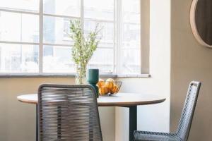 a table with two chairs and a vase on it at Stylish 1BR in Durban
