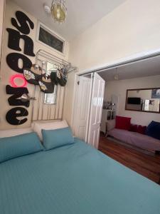 a bedroom with a blue bed and a living room at Two Top Central Artisan Beach Studios - separate Spa Cabin in Brighton & Hove