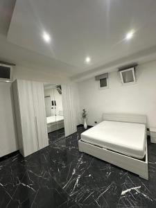 a bedroom with a white bed and a mirror at Casa Birmano in Taranto