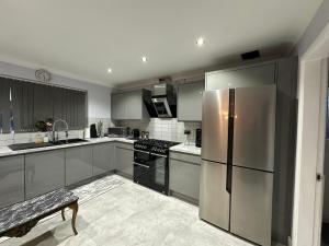 a kitchen with a stainless steel refrigerator and appliances at Contractors Home - 4 Bedroom Long Stays Welcome - Barnsley in Shafton