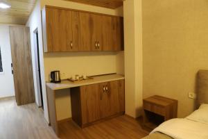 a small kitchen with wooden cabinets in a bedroom at Lalveri INN in Mestia
