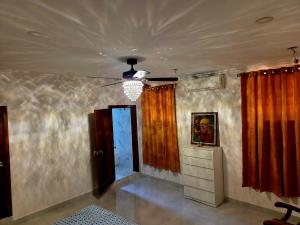 a room with orange curtains and a ceiling at takara stay in Delmas