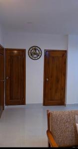 a room with two wooden doors and a clock on the wall at takara stay in Delmas +1 photo