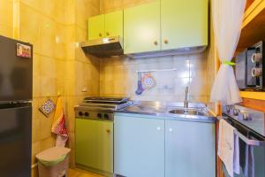 a small kitchen with green cabinets and a sink at Dimora Levante - Pool & Tennis in Noicattaro +23 photos
