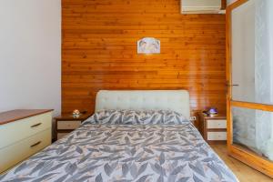 a bedroom with a bed and a wooden wall at Dimora Levante - Pool & Tennis in Noicattaro