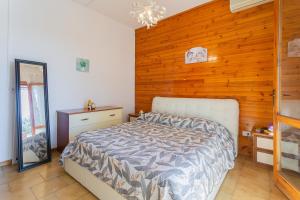 a bedroom with a bed and a wooden wall at Dimora Levante - Pool & Tennis in Noicattaro
