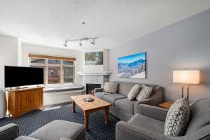 a living room with a couch and a tv at Lake Placid Lodge by Whiski Jack in Whistler