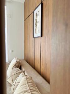 a bed in a room with a wooden wall at Apartments Fat e Jet - Pool & Breakfast in Ulcinj
