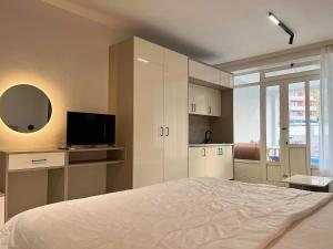 a white bedroom with a bed and a television at Apartments Fat e Jet - Pool & Breakfast in Ulcinj +45 photos