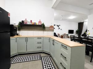 a kitchen with white cabinets and a black refrigerator at Seabreeze Hideout at Pantai Klebang Netflix I Wifi I Massage Chair I 7 pax in Malacca