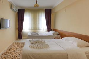 A bed or beds in a room at Gizem Pansiyon