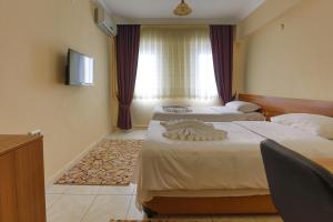 A bed or beds in a room at Gizem Pansiyon