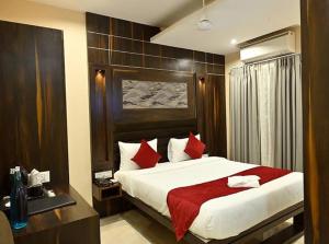ein Schlafzimmer mit einem großen Bett und roten Kissen in der Unterkunft Insfra Hotel in Khatīma
