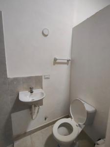 a bathroom with a toilet and a sink at Hospedaje Monasterio in Buga