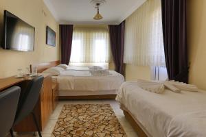 A bed or beds in a room at Gizem Pansiyon