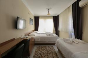 a hotel room with two beds and a window at Gizem Pansiyon in Çanakkale