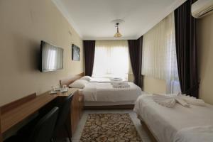 A bed or beds in a room at Gizem Pansiyon Még 37 kép