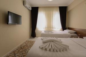 A bed or beds in a room at Gizem Pansiyon