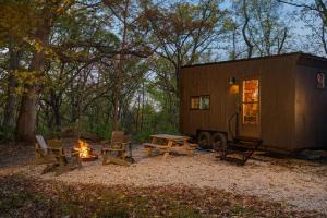a tiny house with a picnic table and a fire at Postcard Cabins Homochitto, Outdoor Collection by Marriott Bonvoy in Meadville