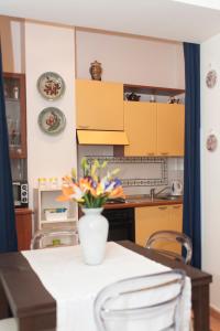 una cocina con un jarrón de flores sobre una mesa en Insidesalernohome, en Salerno