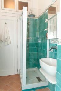 Baño de azulejos verdes con lavabo y aseo en Insidesalernohome, en Salerno
